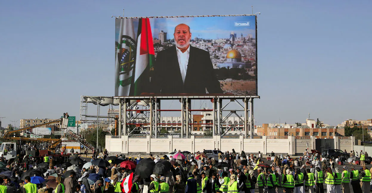 Protesters, mainly Houthi supporters, stand near a screen displaying Senior Hamas official Khalil al-Hayya. File Photo: Reuters