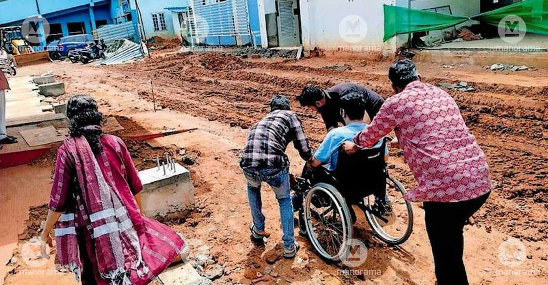 A patient being taken on a wheelchair through the muddy stretch near the dialysis unit and pay ward at Palakkad District Hospital. Photo: Special arrangement