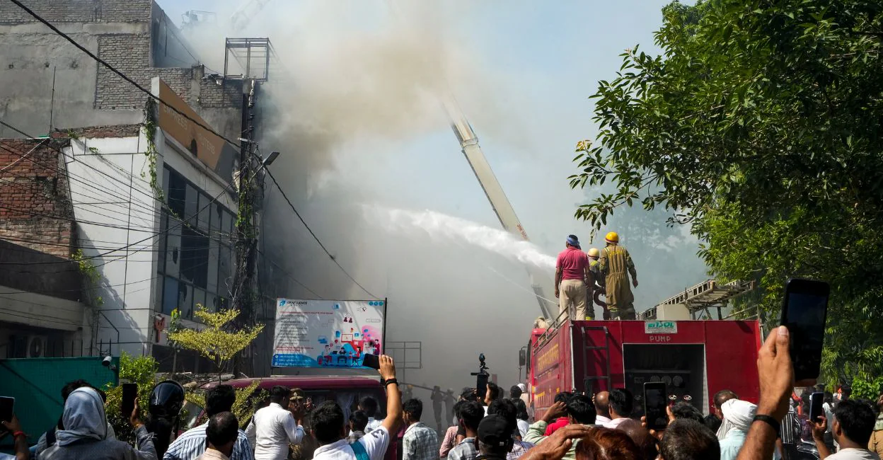 Fire personnel conduct a dousing operation after a fire broke out at a commercial building in Aliganj, Lucknow, Uttar Pradesh, on Monday. Photo: PTI