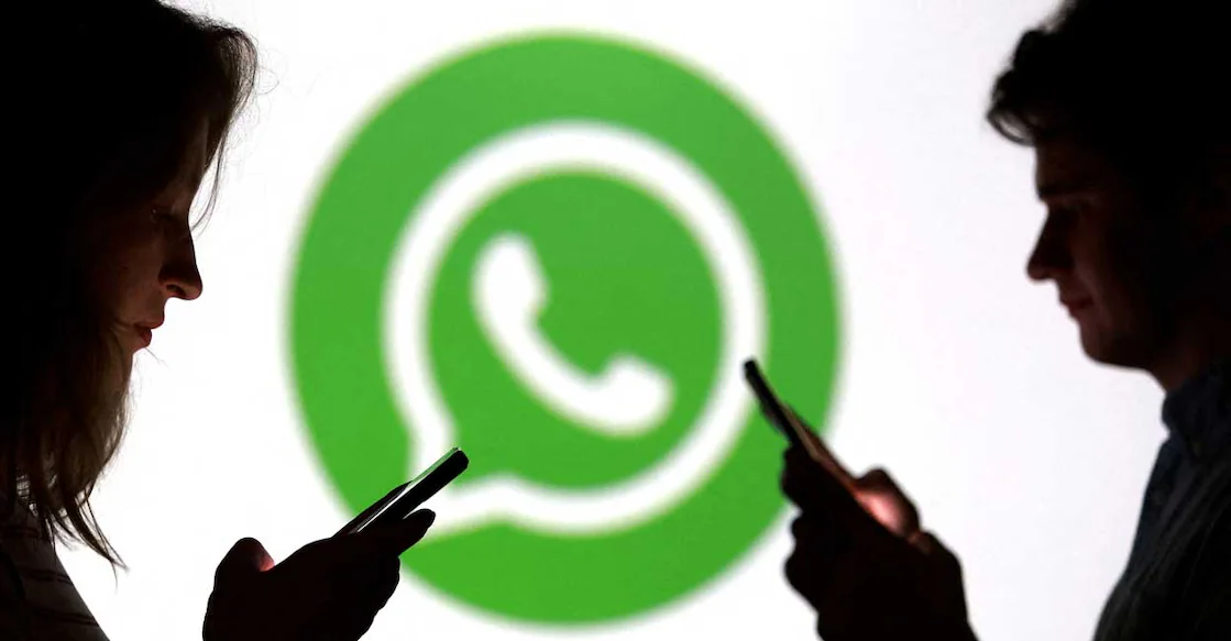 Teenagers pose for a photo while holding smartphones in front of a Whatsapp logo in this illustration taken September 11, 2025. File Photo: REUTERS/Dado Ruvic/Illustration