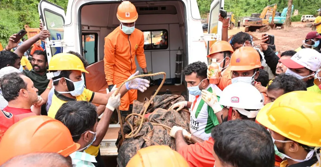 Officials and volunteers involved in the search operation carry the body of Vikram Rana to an ambulance after it was recovered from the landslip site at Kalladi in Wayanad. Photo: Special Arrangement.