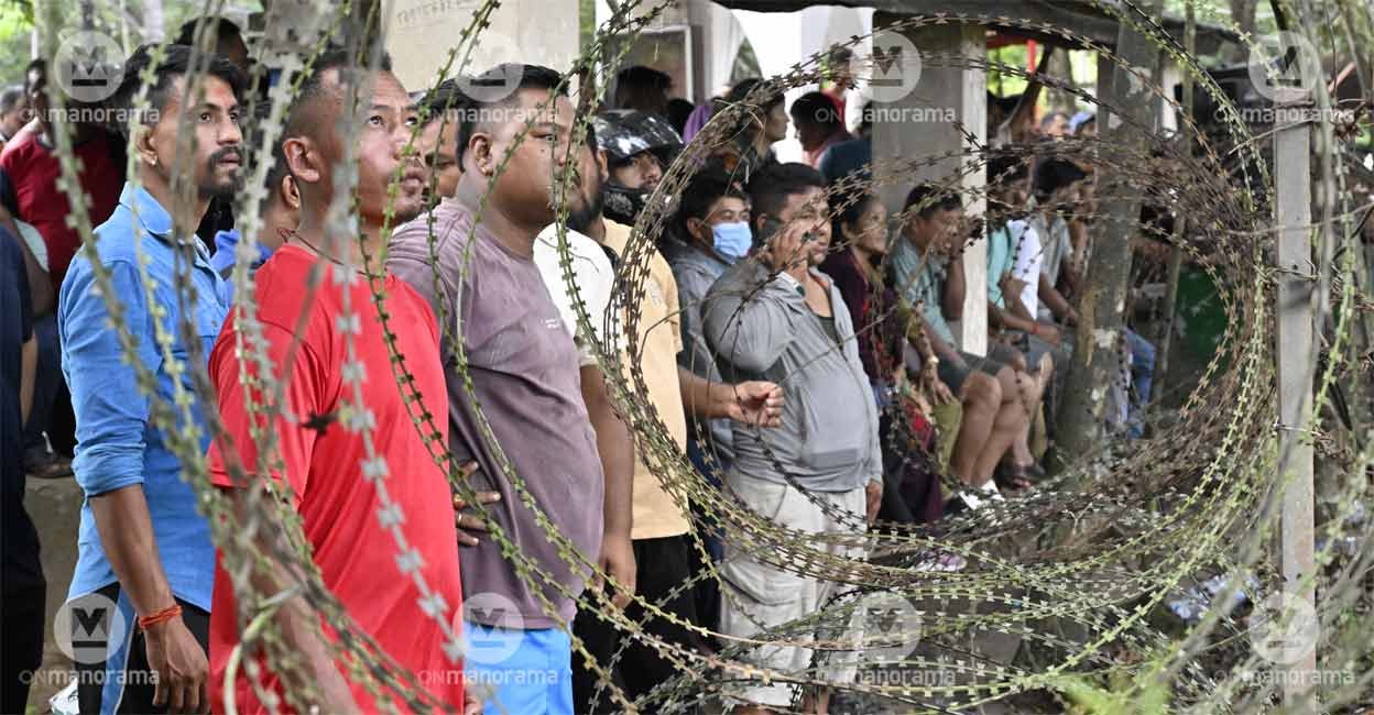 Relatives and friends waiting near a barbed-wire fence for those rescued from the flood-hit areas in Nepal to be brought to the army camp in Nuwakot by helicopter. Photo: Josekutty Panackal/Manorama